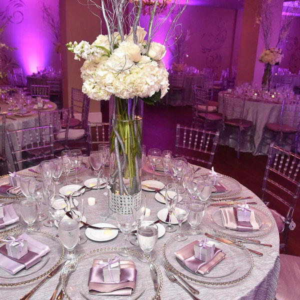 silver and pink table decorations with tall white floral centerpiece